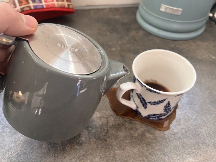 Pouring from a traditional teapot into a mug