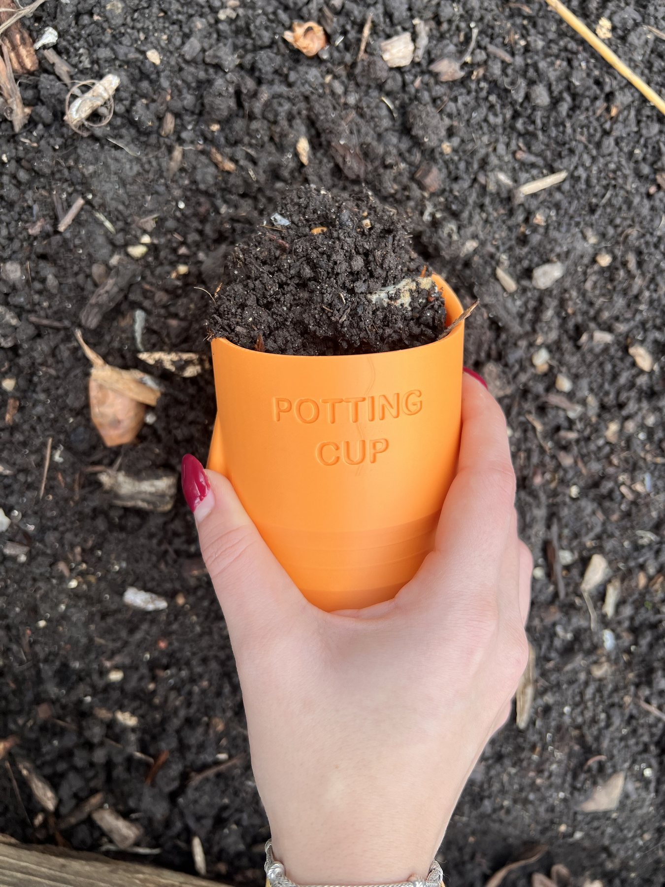 A gardener holding a Potting Cup full of compost