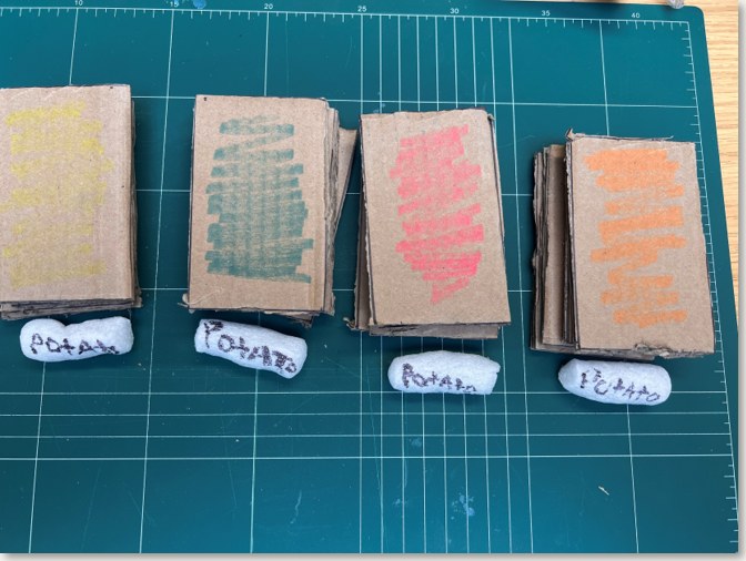 Four coloured card stacks with foam peanut potatoes